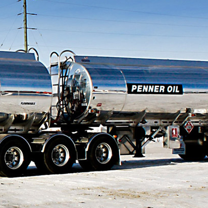 Shiny Penner Oil tanker truck parked on winter road.